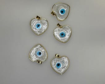 Colgante con dije de corazón y ojo turco transparente con borde dorado y cristal