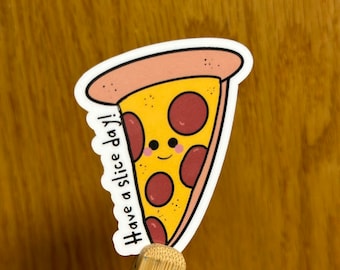Può includere: Un adesivo a forma di fetta di pizza con una faccia sorridente e la scritta "Have a slice day!". L'adesivo presenta una crosta gialla, peperoni rossi e una crosta marrone chiaro. L'adesivo è su sfondo bianco.