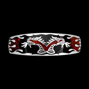 May include: A silver ring with a black enamel band and a design of two dragons facing each other. The dragons are outlined in silver and have red and white accents. The band is surrounded by a design of flames.