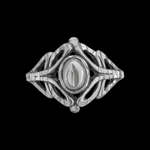 May include: A silver ring with an oval, polished center stone. The ring features an openwork design with intricate, flowing patterns and a textured finish. The ring is set against a black background.