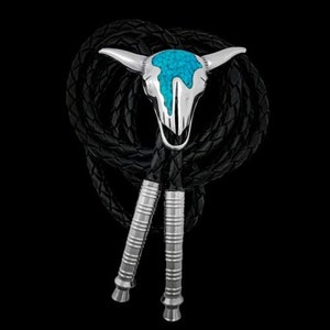 May include: A silver bolo tie with a turquoise and silver skull design. The bolo tie is made of black leather cord and has a silver clasp.