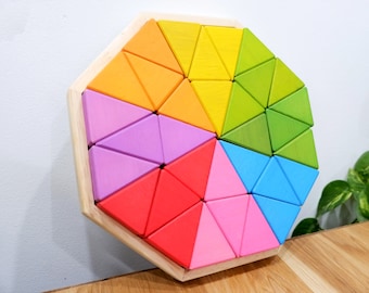 May include: A wooden octagon-shaped puzzle with a rainbow of colors. The puzzle is made up of 24 triangular pieces that fit together to create a larger design. The puzzle is a great way to develop fine motor skills and problem-solving abilities.