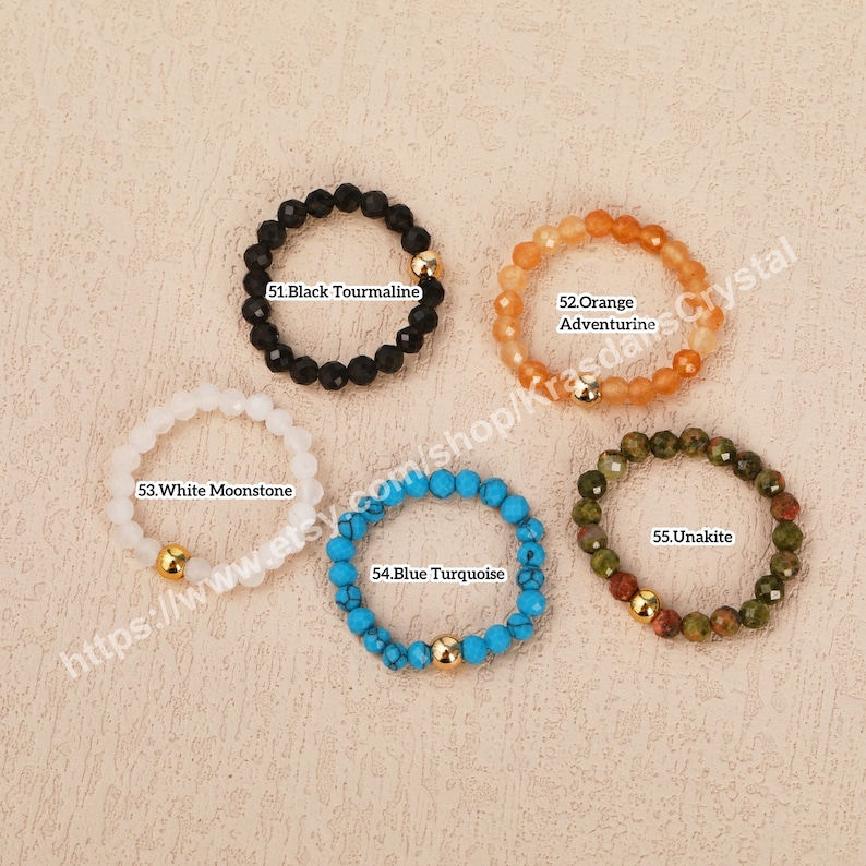 Peut inclure: Cinq bracelets en pierres pr&eacute;cieuses avec des accents dor&eacute;s. Les bracelets sont en tourmaline noire, aventurine orange, pierre de lune blanche, turquoise bleue et unakite.