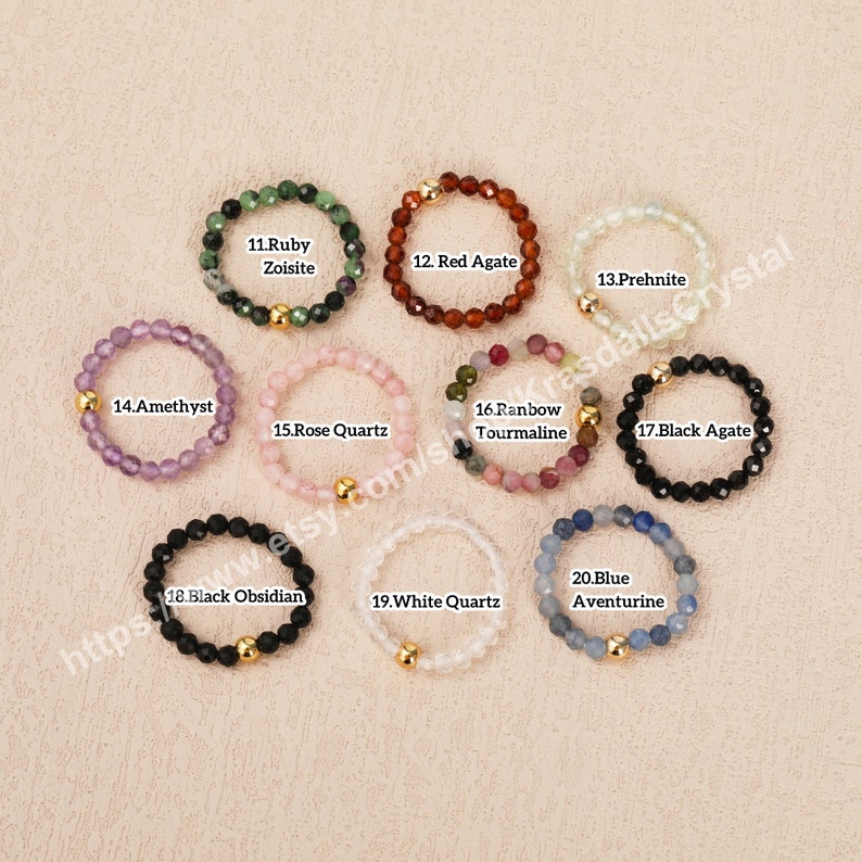 Peut inclure: Dix bagues en pierres pr&eacute;cieuses avec des perles dor&eacute;es. Les bagues sont faites de diff&eacute;rentes pierres pr&eacute;cieuses, dont le rubis, l'agate rouge, la pr&eacute;hnite, l'am&eacute;thyste, le quartz rose, la tourmaline arc-en-ciel, l'agate noire, l'obsidienne noire, le quartz blanc et l'aventurine bleue.