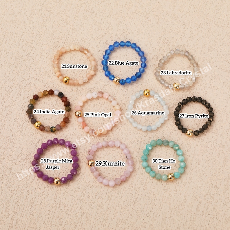 Peut inclure: Dix bagues en pierres pr&eacute;cieuses diff&eacute;rentes avec des accents dor&eacute;s. Les bagues sont dispos&eacute;es en deux rang&eacute;es de cinq. Les pierres pr&eacute;cieuses sont&nbsp;: pierre de soleil, agate bleue, labradorite, agate d&rsquo;Inde, opale rose, aigue-marine, pyrite de fer, jaspe mica violet, kunzite et pierre de tian he.