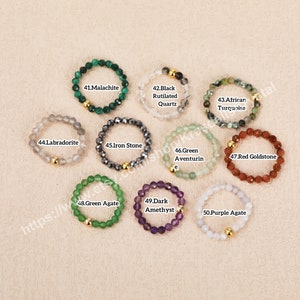 Peut inclure: Dix bagues en pierres pr&eacute;cieuses avec des accents dor&eacute;s. Les bagues sont en malachite, labradorite, pierre de fer, aventurine verte, goldstone rouge, agate verte, am&eacute;thyste fonc&eacute;e et agate violette.