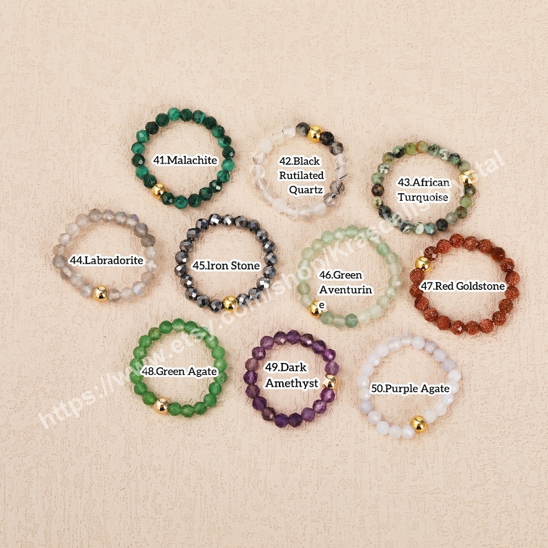 Peut inclure: Dix bagues en pierres pr&eacute;cieuses avec des accents dor&eacute;s. Les bagues sont en malachite, labradorite, pierre de fer, aventurine verte, goldstone rouge, agate verte, am&eacute;thyste fonc&eacute;e et agate violette.