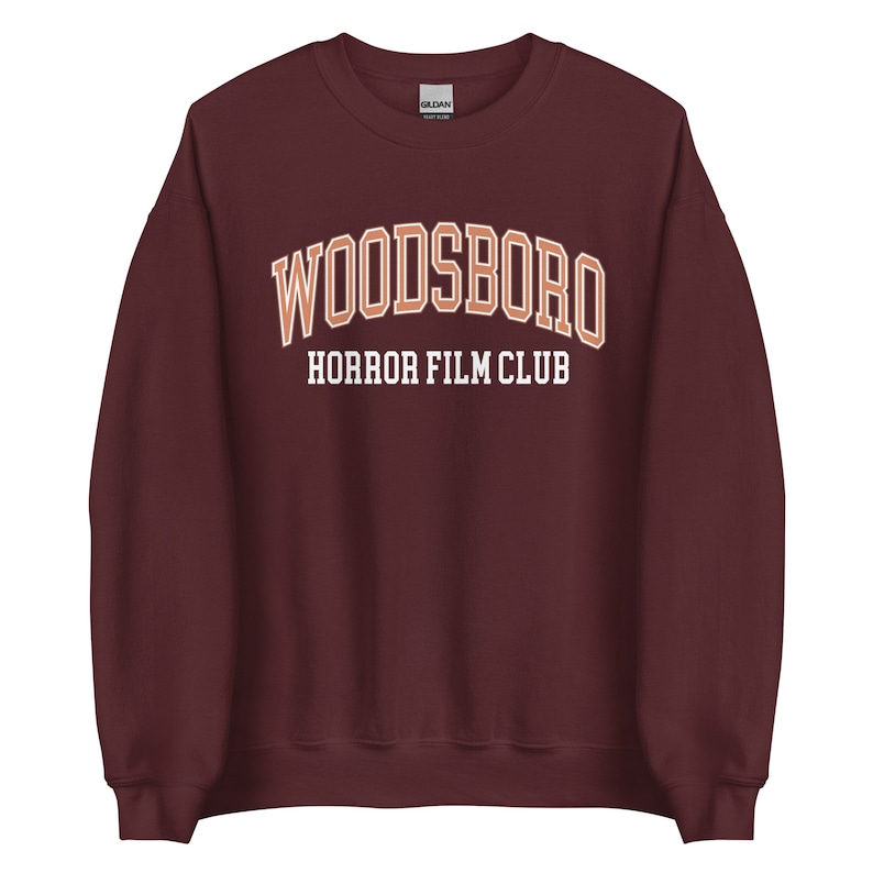 May include: Burgundy sweatshirt with the text "WOODSBORO HORROR FILM CLUB" in orange and white.