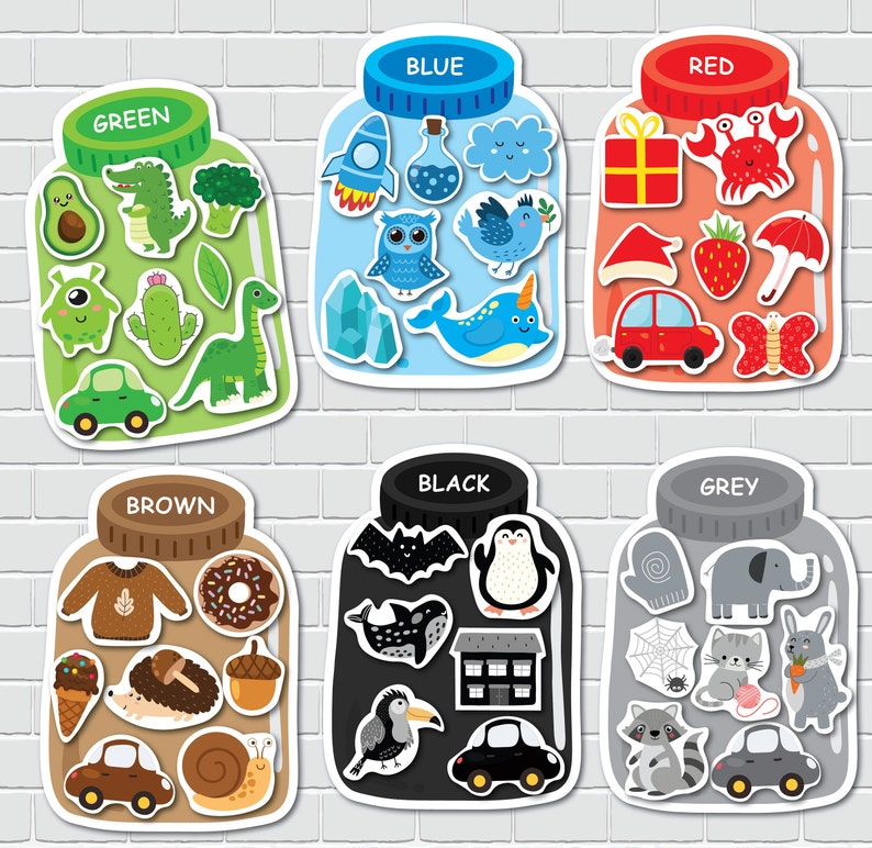 May include: Six colorful jars with different objects inside. Each jar has a label with a color name: Green, Blue, Red, Brown, Black, and Grey. The objects inside each jar are related to the color of the jar.