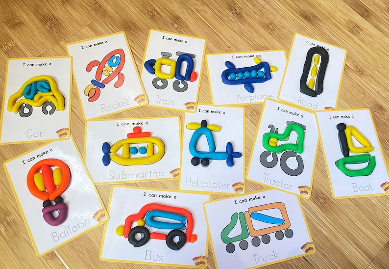 May include: A set of 12 colorful cards with images of different vehicles made from playdough. Each card has the words "I can make a" and the name of the vehicle printed on it. The vehicles include a car, rocket, train, submarine, helicopter, balloon, airplane, road, tractor, boat, bus, and truck.