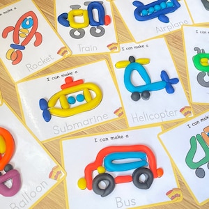 May include: A set of 10 colorful play dough cards with the words "I can make a" and the name of a vehicle or object, such as "car", "rocket", "train", "airplane", "road", "submarine", "helicopter", "tractor", "truck", and "balloon".