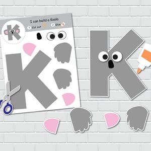 May include: A printable craft activity for kids to build a koala. The craft includes a gray letter K, two gray ears, two gray paws, two pink noses, and two white eyes. The instructions say "I can build a Koala" and include steps to cut out and glue the pieces together.