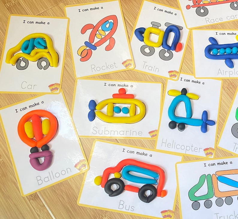 May include: A set of ten colorful play dough cards with images of different vehicles and objects. Each card has a title and the phrase "I can make a" at the top. The cards include a car, rocket, train, airplane, submarine, helicopter, balloon, bus, and truck.
