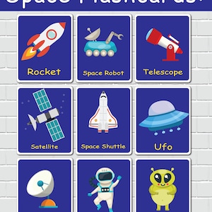 May include: Nine colorful flashcards with illustrations of space-related objects and their names in yellow text. The illustrations include a rocket, space robot, telescope, satellite, space shuttle, UFO, antenna, astronaut, and alien.