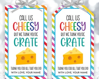 May include: Two colourful gift tags with a cheese pun. The tags have a rainbow striped background and say "Call us cheesy but we think you're grate".  Each tag has a cartoon image of a slice of cheese.