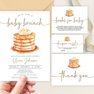May include: A baby shower invitation with a watercolor illustration of a stack of pancakes with syrup and whipped cream. The invitation says "Join for a baby brunch" and includes the name "Olivia Johnson", the date, time, and location of the event. The invitation also includes a request for guests to bring a book in place of a card, and a diaper raffle.