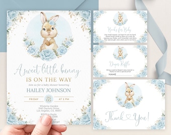 May include: A baby shower invitation with a blue and white colour scheme. The invitation features a cute bunny rabbit with blue flowers and gold glitter. The text on the invitation reads "A sweet little bunny is on the way" and "Hailey Johnson".
