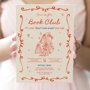以下が含まれることがあります： 赤色の装飾的な渦巻きとテキストが特徴の、クリーム色のブッククラブの招待状。「Join us for Book Club」と書かれており、日付、時間、場所（National Library、ロサンゼルス）が含まれています。招待状には、RSVP情報も含まれています。