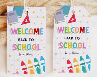 Puede incluir: Dos etiquetas de regalo de bienvenida de regreso a la escuela coloridas con un patrón de cuadrícula, estrellas y útiles escolares. El texto en las etiquetas dice "Bienvenido de regreso a la escuela" y "de Olivia".
