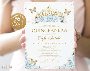 May include: A white invitation card with gold and blue accents. The card features a gold crown with blue roses and butterflies. The text on the card reads "MR. & MRS. LOPEZ INVITE YOU TO CELEBRATE THE QUINCEAÑERA OF THEIR DAUGHTER Sofia Isabella SATURDAY, NOVEMBER 26, 20XX Mass at 11 o'clock St. Joseph Catholic Church, 3145 Doctors Drive, Los Angeles, CA Reception at 12 o'clock Palm Breeze Hotel Restaurant 3145 Doctors Drive, Los Angeles, CA Roup to Kayla at 310-341-3368 by November 5"