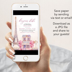 Puede incluir: Una invitaci&oacute;n de baby shower rosa y blanca con una ilustraci&oacute;n de acuarela de la Torre Eiffel y una cafeter&iacute;a parisina. La invitaci&oacute;n dice "bonjour bibi" e incluye detalles del evento, como la fecha, la hora y el lugar.