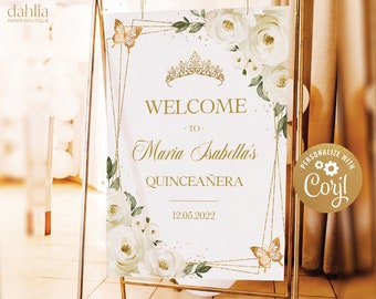 Peut inclure: Une pancarte de bienvenue blanche et dorée avec un fond de paillettes dorées. La pancarte présente une couronne dorée, des fleurs blanches et des papillons. Le texte sur la pancarte indique "Bienvenue à Maria Isabella's Quinceañera 12.05.2022".