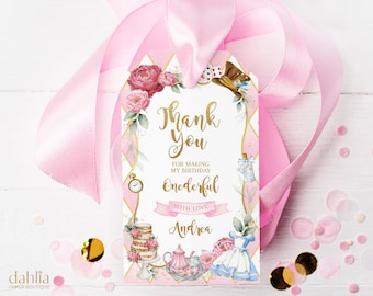 May include: Pink and gold thank you tag with a whimsical Alice in Wonderland theme. The tag features a floral design, a teapot, a cake, and the text "Thank You" and "Onederful".