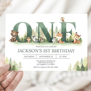 Puede incluir: Una invitación de primer cumpleaños con temática de bosque con una ilustración de acuarela de la palabra "UNO" rodeada de animales del bosque. La invitación incluye el nombre "JACKSON'S 1ST BIRTHDAY", la fecha "SÁBADO, 25 DE NOVIEMBRE", la hora "A LAS 5 PM", la ubicación "The Jackson Residences, 3145 Doctors Drive, Los Angeles, CA, 90017" y la información de RSVP "RSVP a Kayla al 310-341-3368".
