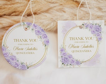 Op de afbeelding: Twee ronde bedankkaartjes met een paars bloemenontwerp en gouden accenten. De tekst op de kaartjes luidt "Bedankt - Voor uw komst naar - Maria Isabella's Quinceañera".