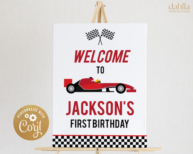May include: Welcome to Jackson's First Birthday sign with a red race car and checkered flag design. The sign is on a wooden easel.