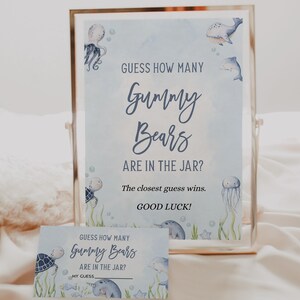 May include: A blue and white printable sign with a watercolour background and sea creatures. The sign says "Guess how many gummy bears are in the jar? The closest guess wins. Good luck!"
