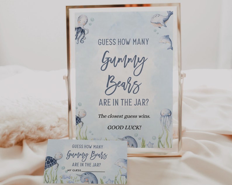 May include: A blue and white printable sign with a watercolour background and sea creatures. The sign says "Guess how many gummy bears are in the jar? The closest guess wins. Good luck!"