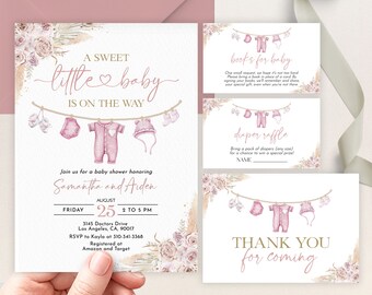 May include: A pink and gold baby shower invitation with a watercolor illustration of baby clothes hanging on a clothesline. The invitation says "A Sweet Little Baby Is On The Way" and includes the names Samantha and Aiden, the date August 25th, and the time 2 to 5 PM. The invitation also includes the address 3145 Doctors Drive, Los Angeles, CA, 90017, and the RSVP information to Kayla at 310-341-3368. The invitation also says "Registered at Amazon and Target".