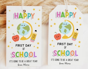 Puede incluir: Dos etiquetas de regalo coloridas con un diseño de globo terráqueo, lápiz y manzana. El texto en las etiquetas dice "Feliz primer día de escuela" y "¡Va a ser un gran año!" con el nombre "Olivia" en la parte inferior.