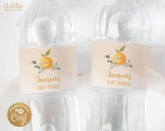 May include: Two clear plastic water bottles with labels. The labels are peach colored with a cartoon orange with a smiling face and green leaves. The text on the labels reads "Lauren's Baby Shower".