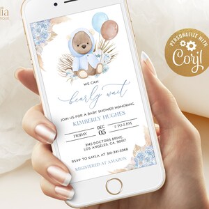 Pu&ograve; includere: Un invito a una festa di baby shower blu e marrone con un orsacchiotto che indossa un maglione con cappuccio blu e tiene un palloncino blu. L'invito dice "We can bearly wait" e include la data, l'ora e il luogo della festa. L'invito &egrave; personalizzato con il nome "Coril".