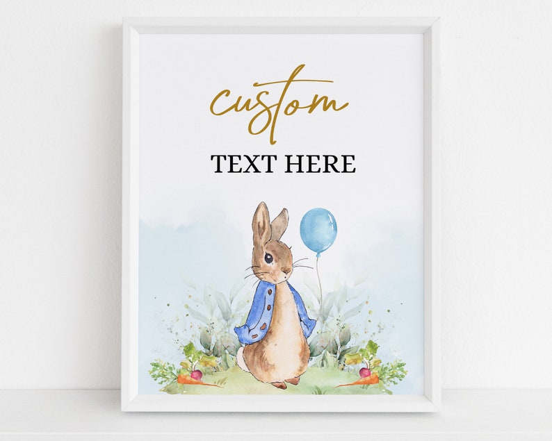 May include: A printable poster featuring a watercolor illustration of Peter Rabbit holding a blue balloon. The poster has the text "custom" and "TEXT HERE" in gold and black.