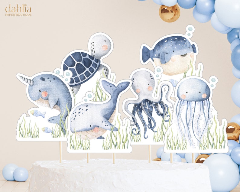 Puede incluir: Conjunto de seis adornos para tartas de acuarela azul y blanca con una narval, una ballena, una tortuga, un pulpo, una medusa y un pez globo. Los adornos son perfectos para una fiesta de tem&aacute;tica n&aacute;utica.