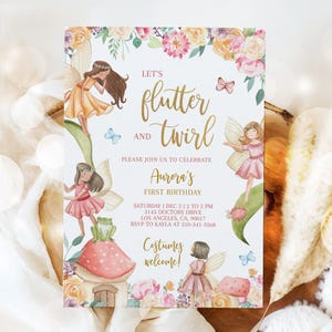 May include: A white invitation with a floral border and gold lettering. The text reads "Let's flutter and twirl. Please join us to celebrate Aurora's First Birthday. Saturday, Dec 5, 12 to 5 PM, 3145 Doctors Drive, Los Angeles, CA, 90017. RSVP to Kayla at 310-341-3368. Costumes welcome!" The invitation features illustrations of fairies and butterflies.
