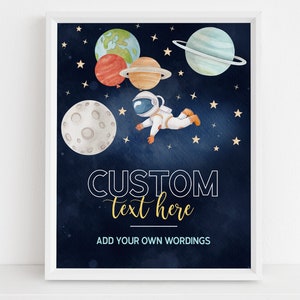 May include: A printable poster with a blue background featuring an astronaut floating in space with planets and stars. The text "CUSTOM text here" is written in gold and black. The text "ADD YOUR OWN WORDINGS" is written in blue.