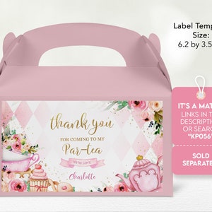 May include: Pink and gold favor box with a tea party theme. The box has a handle and features a watercolor illustration of a teapot, cupcakes, and flowers. The text on the box reads "thank you for coming to my Par-tea with love Charlotte".