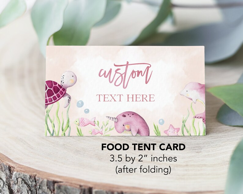 May include: Pink and blue food tent card with a sea turtle, narwhal, and dolphin illustration. The text "custom TEXT HERE" is on the card. The card measures 3.5 by 2 inches when folded.