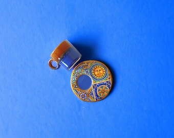 May include: A blue and gold ceramic teacup and saucer set with a sun and floral design.