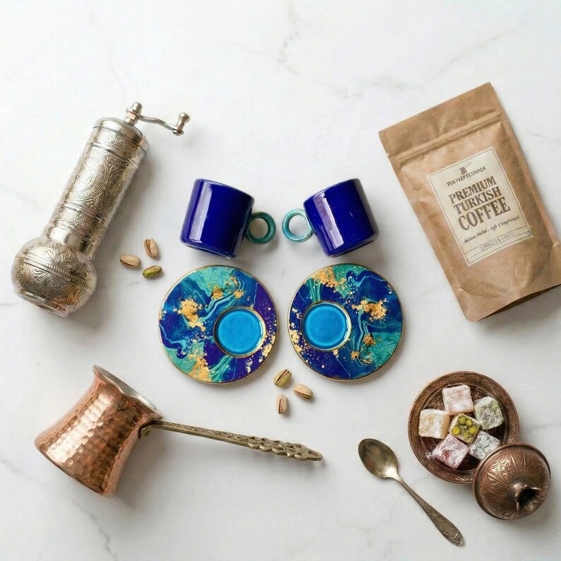 Premium variation of the coffee gift set featuring handmade artisan green ceramic espresso cups surrounded by a copper cezve and silver grinder.