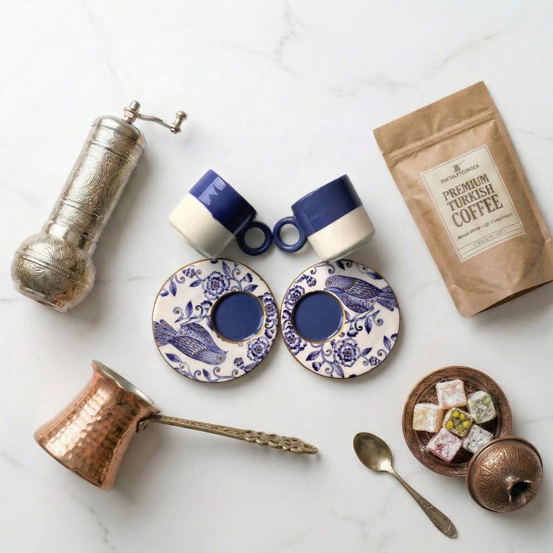 Premium variation of the coffee gift set featuring handmade artisan green ceramic espresso cups surrounded by a copper cezve and silver grinder.