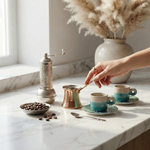 May include: A set of three ceramic mugs with a speckled, matte finish. The mugs are in shades of cream, light brown, and dark brown. Each mug has a simple, minimalist design, perfect for coffee or tea.