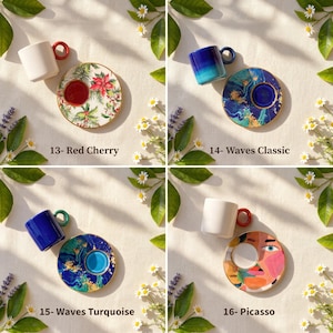 Puede incluir: Cuatro juegos de tazas y platillos decorativos. Los juegos incluyen una taza blanca con asa roja y platillo floral, una taza azul con platillo azul y dorado, una taza azul con platillo turquesa y una taza blanca con platillo estilo Picasso. Texto en la imagen: 13- Red Cherry, 14- Waves Classic, 15- Waves Turquoise, 16- Picasso.