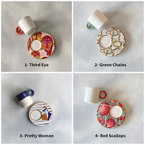 May include: Four different sets of espresso cups and saucers with colorful designs. The designs include a third eye, green chains, a pretty woman, and red scallops.