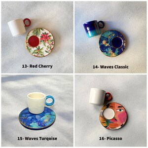 Puede incluir: Cuatro juegos diferentes de taza y platillo de caf&eacute;. El primer juego tiene una taza y un platillo blancos con un dise&ntilde;o de cerezas rojas. El segundo juego tiene una taza y un platillo azules con un dise&ntilde;o de olas azules y verdes. El tercer juego tiene una taza blanca con un asa azul y un platillo con un dise&ntilde;o de olas azules y verdes. El cuarto juego tiene una taza y un platillo blancos con un dise&ntilde;o abstracto colorido.