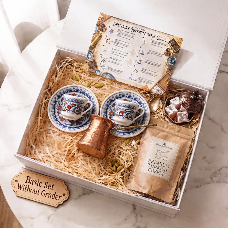 May include: A white gift box with a Turkish coffee set. The set includes two small cups and saucers with blue and red floral designs, a copper coffee pot, a bag of coffee, and a guide. The box also contains a wooden sign that says "Basic Set Without Grinder."